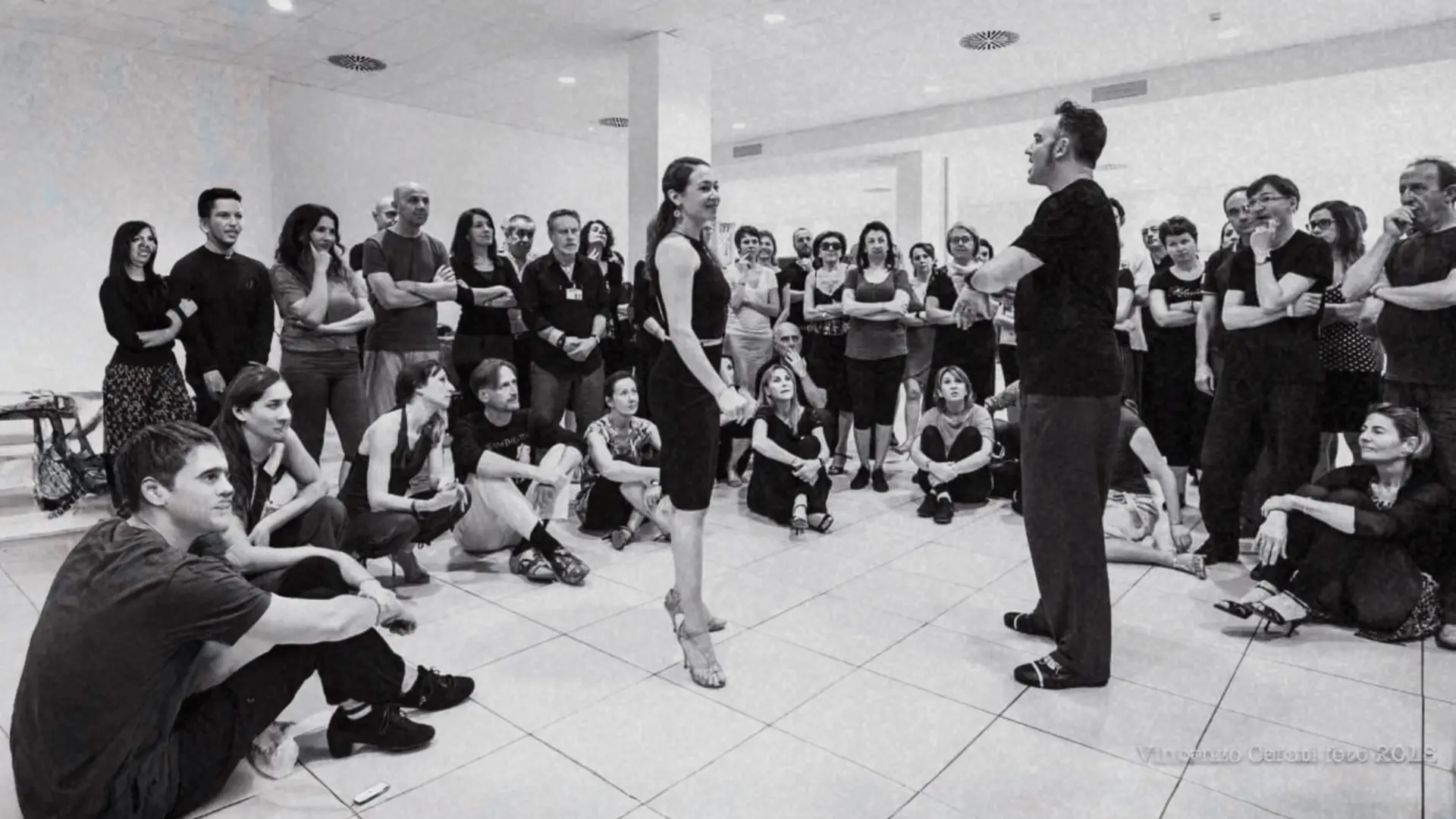 Un grupo de participantes reunido en círculo durante una clase de tango.